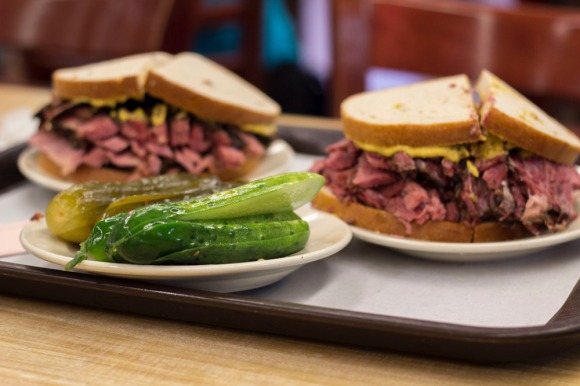 A plate of pickles, a pastrami on rye, and a corned beef on rye at Katz's Delicatessen