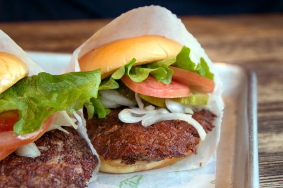 Two Shake Shack hamburgers with lettuce, tomato, pickle, and onion